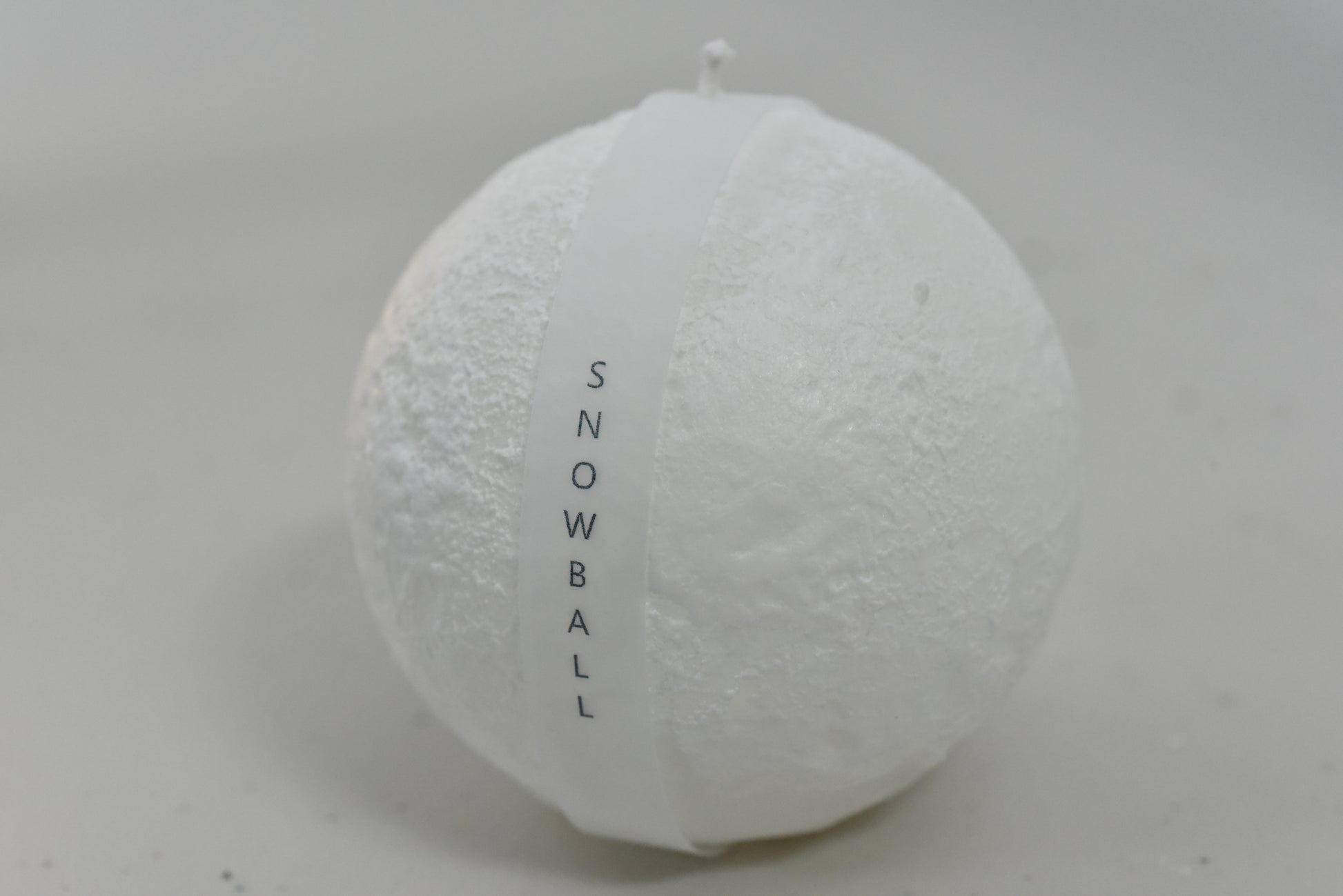 Unlit Snowball Candle displayed elegantly, highlighting its unique snowball shape.
