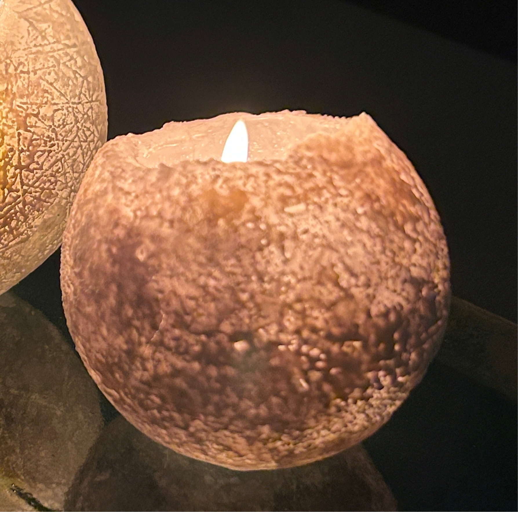 User inserting tealight into the Snowball Candle, demonstrating its practical design.